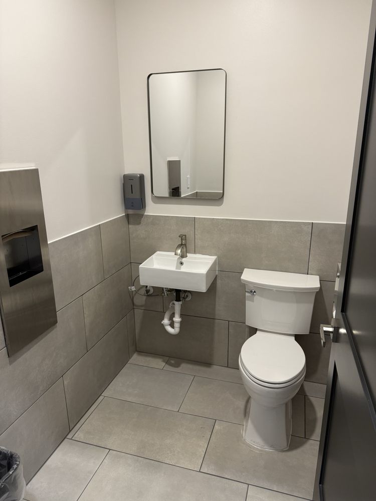 Freshly renovated customer restroom at Retro Laundry Co. in San Antonio with new tile, modern fixtures, and spotless finishes